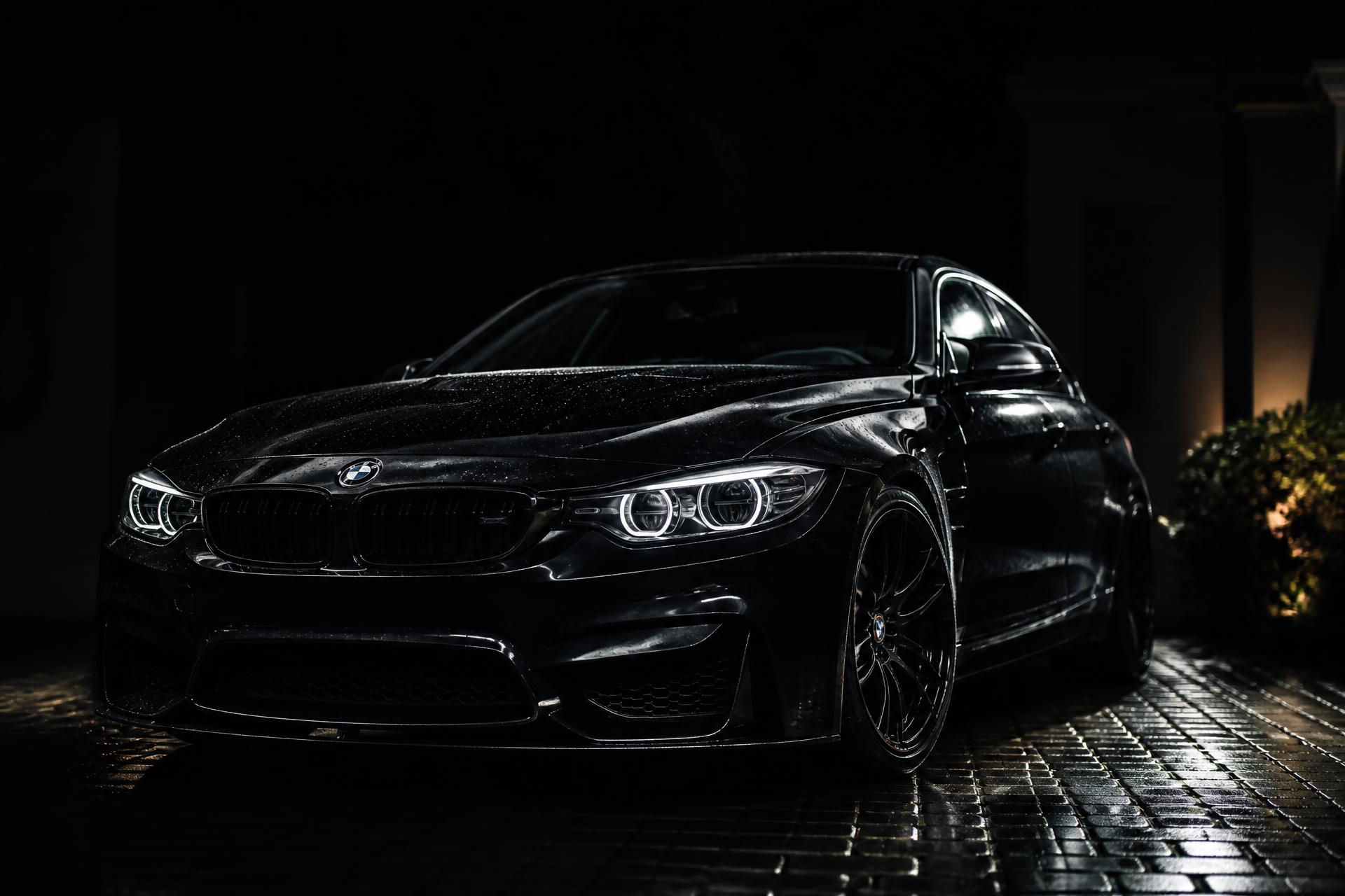Freshly detailed black car gleaming at night in a driveway